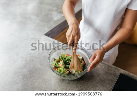 caucasian woman preparing chiken breasts , healthy meal in her rustic eco open kitchen