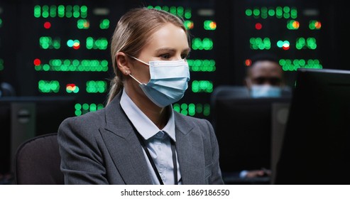 Caucasian Woman IT Programer Working On Desktop Computers In Data Center Control Room Young Digital Engineer Working On Computer Checking Cyber Security On Data Server Sitting In Mask At Work Close Up