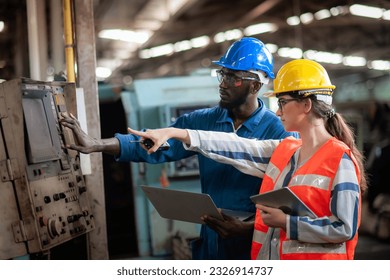 Caucasian woman programmer engineer and Indian man Technician operator machine is working in factory, checking lathe machinery operating with laptop to maintain safety of work, Safety first concept. - Powered by Shutterstock