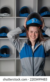 Caucasian Woman Puts On A Helmet Before Flying In A Wind Tunnel. Free Fall Simulator.