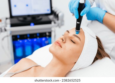 Caucasian woman receiving facial procedure of cleansing the skin. Portrait and natural woman face with healthy freckle skin texture. Aesthetic, facial and skincare cosmetology
