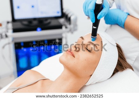 Caucasian woman receiving facial procedure of cleansing the skin. Portrait and natural woman face with healthy freckle skin texture. Aesthetic, facial and skincare cosmetology