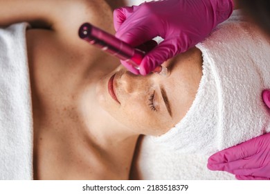 Caucasian Woman Relaxing On Massage Table While Aesthetician Giving Her An Aqua Peeling On Her Face. Cosmetic Beauty Spa Salon. Girl Facial Treatment.