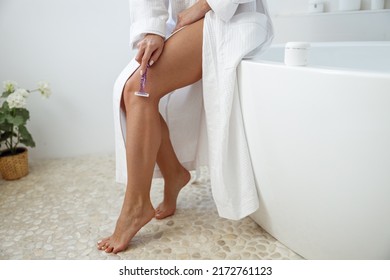 Caucasian woman shaving leg with shaver in bathroom at home. Smooth skincare concept.  - Shutterstock ID 2172761123
