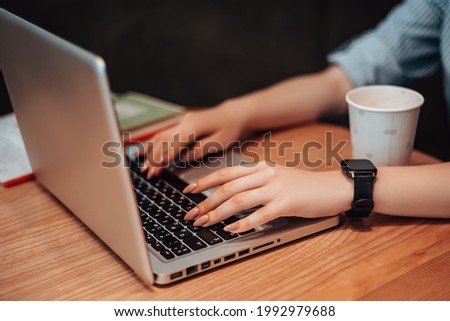 Caucasian woman sitting cafe coffee break drink plastic white cup hot beverage open space work laptop hand on keyboard typing search information. Lady with smart watches on wrist copyspace