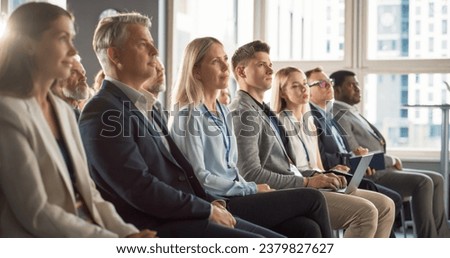 Caucasian Woman Sitting in Crowded Audience at Human Resource Conference. Female Delegate Focused On Presenter. HR Manager Listening to Inspirational Entrepreneurship Presentation About Social Studies