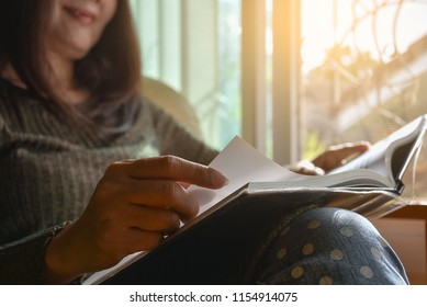 Caucasian woman sitting in living room at home, concentrate on reading book. Use free time and hobby concept.  - Shutterstock ID 1154914075