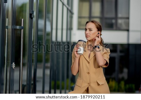 Caucasian woman with smartphone standing against street building background