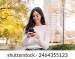 caucasian woman smiling happy using her mobile phone, concept of technology of communication and modern lifestyle, copy space for text