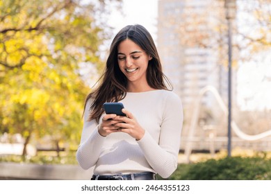 caucasian woman smiling happy using her mobile phone, concept of technology of communication and modern lifestyle, copy space for text - Powered by Shutterstock