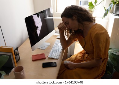 Caucasian woman spending time at home self isolating and social distancing in quarantine lockdown during coronavirus covid 19 epidemic, sitting at a desk with computer, with head on hand - Shutterstock ID 1764103748