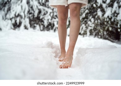 Caucasian woman standing barefoot in snow