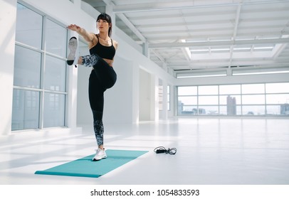 Caucasian Woman In Standing Big Toe Hold Pose At Gym. Female Practising Yoga Asana In Fitness Studio.