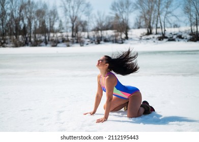 Caucasian woman in a swimsuit sunbathes on the snow in winter.