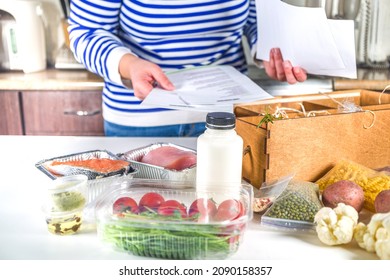 Caucasian woman take apart box with delivery of ingredients, recipes. Meal Kit Delivery Concept. Set various healthy foods with recipes for cooking. Online ordering of restaurant chef grocery delivery