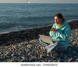 Caucasian Woman Talking By Video Link On Laptop While Sitting On The Beach. 