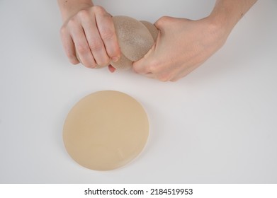 Caucasian Woman Testing The Strength Of A Breast Implant. 