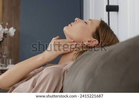 Caucasian woman touching her throat. Sore throat, cold, flu, tonsillitis or thyroid gland problem