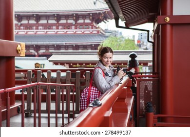 Caucasian Woman A Tourist Walking With Camera In Japanese Shrine Temple, Japan