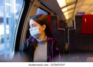 Caucasian Woman Traveler In Face Mask Sitting Inside Train And Looking Out Window.