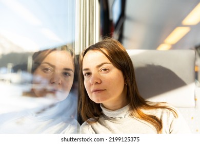 Caucasian Woman Traveler Sitting Inside Train And Looking Out Window.