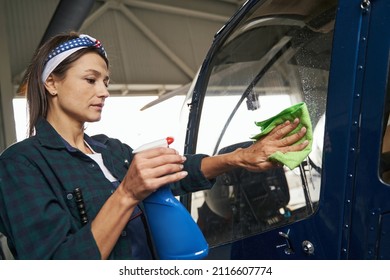 Caucasian Woman In Uniform Polishing Parts Of Aircraft With Microfiber In Hangar