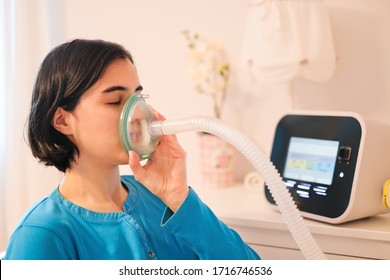 A Caucasian Woman Using A Cough Assist Ventilator Mask For Deep Breaths, Respiratory Condition