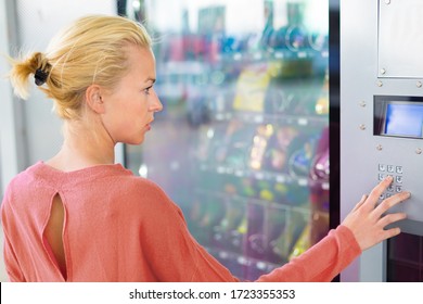 Caucasian Woman Using A Modern Vending Machine. Her Right Hand Is Placed On The Dia Pad.