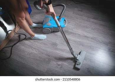 Caucasian woman with a vacuum cleaner in home.