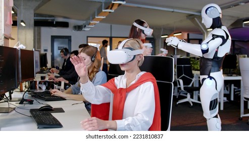 Caucasian woman in VR glasses sitting in office and moving hands in air. female in headset scrolling in space in front of him. Virtual reality. Augmented. Robot on the background. Android. Gamer. - Powered by Shutterstock