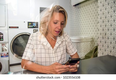 Caucasian woman waiting at the self service laundry - Powered by Shutterstock