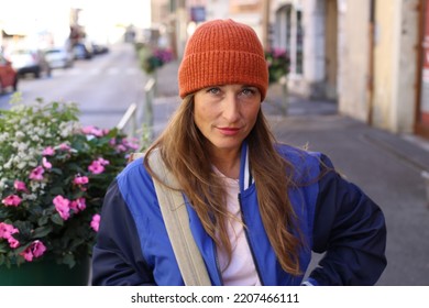 Caucasian Woman Wearing A Beanie And Holding A Backpack Outdoors  