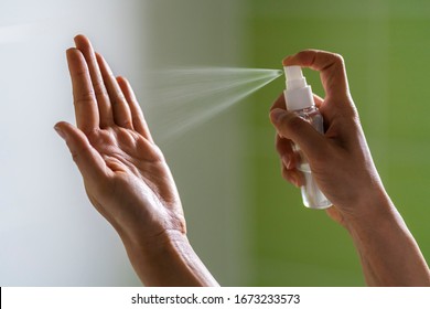 Caucasian woman wipes her hands with an alcohol-based hand-washing spray as a preventive hygiene measure against coronavirus ( Sars-CoV-2, Covid-19) infection. Antibacterial hand sanitizer gel.