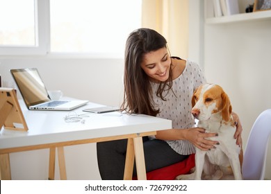 Caucasian Woman Working At Home Office While Her Dog Watching Her/  Businesswoman In Thirties Concept
