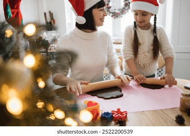 Caucasian woman and young girl baking holiday cookies wearing Santa hats. Warm atmosphere captures joy and bonding in festive kitchen with Christmas decorations. - Powered by Shutterstock