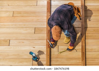 Caucasian Worker Building Wooden Deck For His Backyard Garden. Top View.