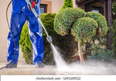Caucasian Worker in His 30s with Pressure Washer Cleaning Residential Driveway. Garden and Home Surrounding Maintenance. - Shutterstock ID 1391109212