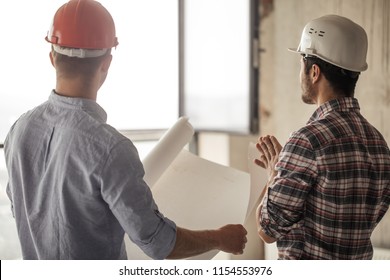 the Caucasian worker showing the work done to the customer. closeup back view photo - Shutterstock ID 1154553976