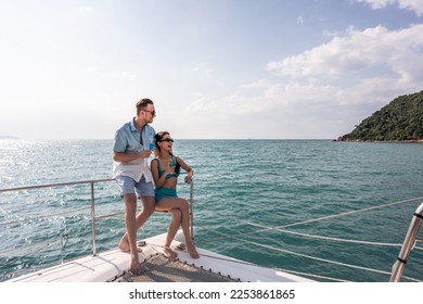 Caucasian young couple drinking champagne while having party in yacht. Attractive man and woman hanging out, celebrating anniversary honeymoon trip while catamaran boat sailing during summer sunset. - Powered by Shutterstock