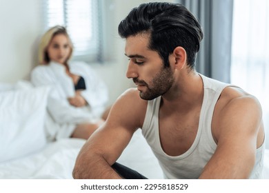 Caucasian young couple sit on bed with painful after fight argument. New marriage man and woman crying and feel heartbroken for their quarrel conflict in bedroom. Family problem-separation concept. - Shutterstock ID 2295818529