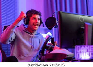 Caucasian young esport male gamer play online video game on computer. Handsome man gaming player feel happy and excited, enjoy technology broadcast live streaming while plays cyber tournament at home. - Powered by Shutterstock