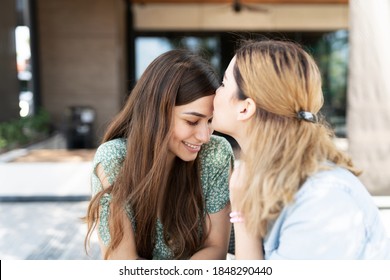 Caucasian Young Gay Women Kissing The Forehead Of Her Smiling Latin Young Girlfriend 