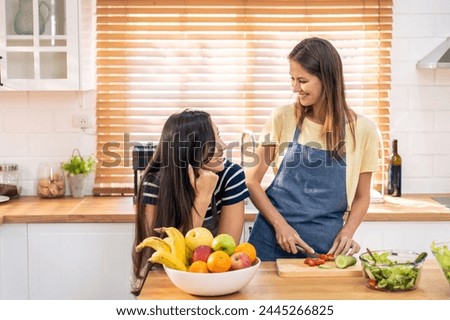Caucasian young lesbian couple spend time together in kitchen at home. Attractive romantic girl friend feel happy and relax, enjoy cooking foods for breakfast with happiness. Homosexual-LGBTQ concept.
