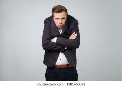 Caucasian Young Man In Too Big Suit. He Is Offended And Looking Stressed. Looking Silly In A Suit Of Wrong Size