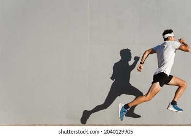 Caucasian Young Man Doing Sport Jumping, Shadow Cast On The Wall