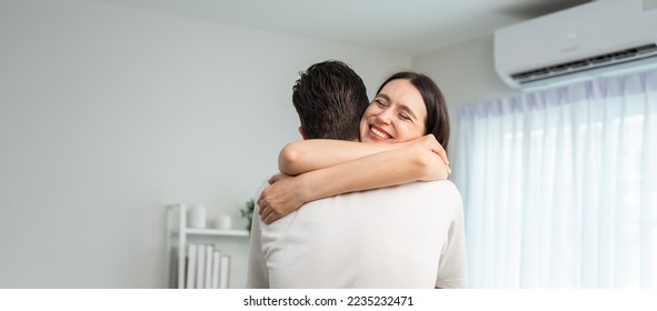 Caucasian young man and woman hugging each other in living room at home. Attractive romantic new marriage couple male and female spend time celebrate anniversary and valentine's day together in house. - Powered by Shutterstock