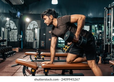 Caucasian young sportsman trainer exercise to build muscle in stadium. Attractive bodybuilder athlete man in sportswear workout by lifting weight dumbbell for health care lifestyle at fitness gym club - Powered by Shutterstock