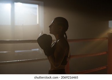 Caucasian Young Sporty Woman With Brunette Hair Practicing Inside Boxing Ring. Female Athlete is Training in Gym, doing a Shadow Fight, Preparing for a Competition - Powered by Shutterstock