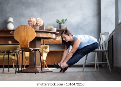 Caucasian young woman doing paschimottanasana sitting on chair. Yoga on working place.