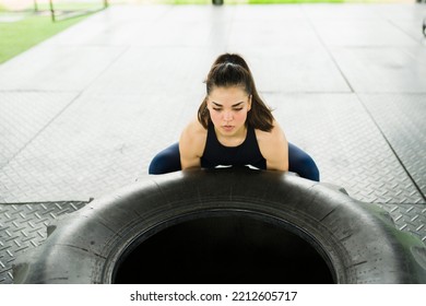 Caucasian Young Woman Doing Tire Flip Exercises For Her Cross Training Workout At The Gym